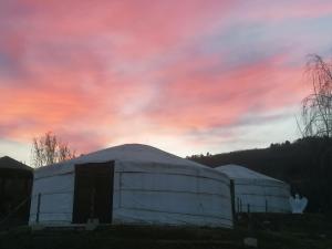 a domed building with a pink sky in the background at Jurta Hotel Balatongyörök in Balatongyörök