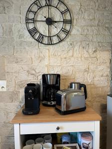 a clock on a wall with a coffee maker and a toaster at Mas Provençal de 120m2 en Camargue, Avec Piscine et Parking inclus, Idéal pour des vacances in Arles