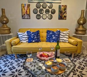 a living room with a yellow couch with a tray of food at QUERTINEUX Historic 4 Châteaux Lastours 3 Star 3 BED air conditioned apartment in Lastours