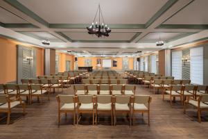 a large room with rows of chairs and a podium at The Riverview Retreat Corbett by Leisure Hotels in Garjia +67 photos
