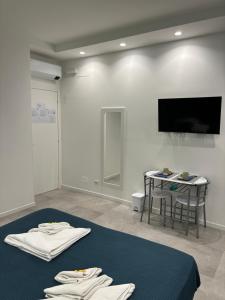 Habitación con cama, mesa y TV. en Casa Marel, en Lido di Ostia