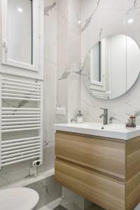 een badkamer met een wastafel en een spiegel bij 667 Suite Clement - Apartment near Paris in Vincennes