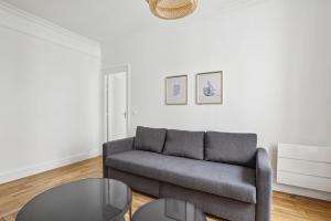 een woonkamer met een bank en een tafel bij 667 Suite Clement - Apartment near Paris in Vincennes