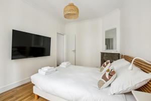 een witte kamer met een bank en een flatscreen-tv bij 667 Suite Clement - Apartment near Paris in Vincennes