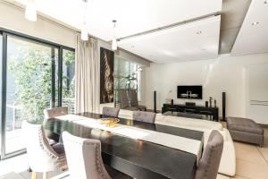 a dining room with a table and chairs at Old House Lane Melrose Boulevard in Johannesburg