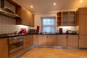 a large kitchen with wooden cabinets and a window at Experience Vibrant Covent Garden - The ZenScape by SmartStays in London
