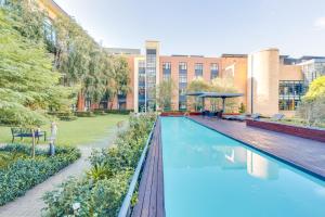 a swimming pool in front of a building at Old House Lane Melrose Boulevard in Johannesburg
