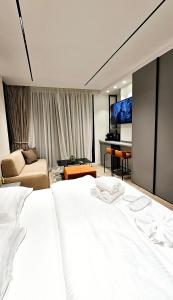 a bedroom with two white beds and a living room at Center Apartment Easy_Luxury in Tirana