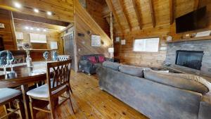 een woonkamer met een bank en een open haard bij Evie's Mountain Castle cabin in Townsend