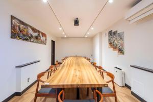 a long wooden table in a room with chairs at 舜芦 芦ノ湖 10名まで同一料金 箱根芦ノ湖 海賊船港まで徒歩2分 bbq 最大16名 in Hakone