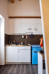 una cocina con armarios blancos y electrodomésticos azules en Cedros, en Palermo