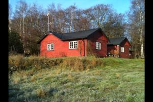 una casa rossa in mezzo a un campo di Sagolikt läge med havsutsikt i Rörum på Österlen a Simrishamn