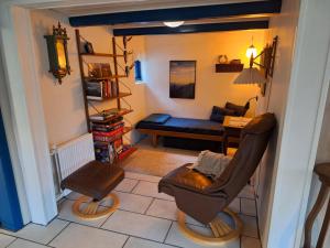 a living room with a chair and a couch at Rødsten Gæstegård in Ulfborg