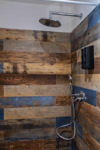 y baño con pared de madera y ducha. en Cedros, en Palermo