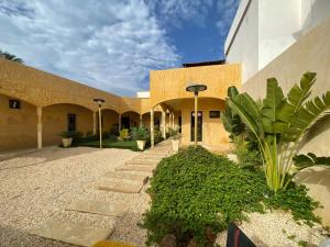 a courtyard of a building with trees and plants at O Cupidon Doré in Sali Nianiaral