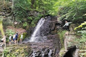 un gruppo di persone che si trovano di fronte a una cascata di Sagolikt läge med havsutsikt i Rörum på Österlen a Simrishamn