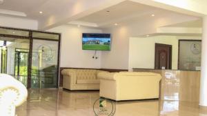 a living room with two couches and a flat screen tv at Koru Country Club in Muhoroni