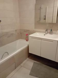 un bagno bianco con lavandino, vasca e vasca da bagno di 2BHK Entire Apartment fully equipped 84m2 a Lione