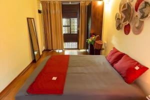 a bedroom with a bed with red pillows on it at Linna's Home - City Center - Hanoi Old Quarter - Spacious - Train street in Hanoi