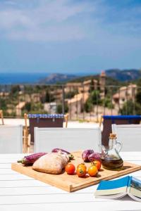 a cutting board with vegetables on top of a table at Sa Garrigueta FH, stunning views in Galilea