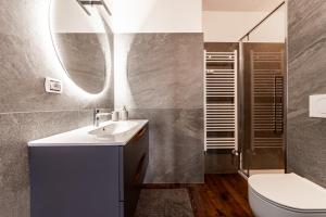 Un baño con lavabo, inodoro y espejo. en Chalet sulle piste a Cervinia con parcheggio, en Breuil 26 fotos más