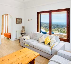 a living room with a couch and a table at Sa Garrigueta FH, stunning views in Galilea