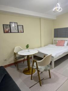 a room with a bed and a table and a table and chair at Studio Guest Suite Near The New EVRMC Hospital & San Juanico Bridge Tacloban City, Leyte, Philippines in Tacloban