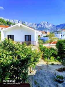 a white house with mountains in the background at Apartments Tamaris in Zaostrog