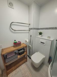 a bathroom with a toilet and a wooden table at Апартаменты in Rīga
