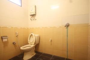 a bathroom with a toilet and a phone on the wall at Hotel Villa Rawa Pening Pratama by Aparian in Bandungan