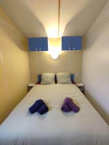 Schlafzimmer mit einem großen weißen Bett und blauen Schränken in der Unterkunft Mobil-home 2 