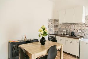 a kitchen with a table with a vase of flowers on it at Alla Fiera apartment in Bergamo