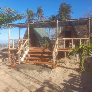 ein Haus am Strand mit Palmen im Hintergrund in der Unterkunft Tiliponan in Buenavista