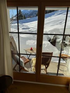 Aussicht aus einem Fenster eines Zimmers mit einem Tisch in der Unterkunft Chalet Studio - Top Ausstattung - beste Lage Davos in Davos