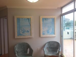 two chairs in a room with two pictures on the wall at Rondevoux 27 in Margate