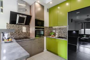 uma cozinha com armários verdes e uma bancada em ShortStayPoland Aleja Rzeczypospolitej (B157) em Varsóvia