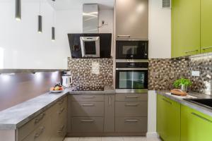 uma cozinha com armários e electrodomésticos verdes e brancos em ShortStayPoland Aleja Rzeczypospolitej (B157) em Varsóvia