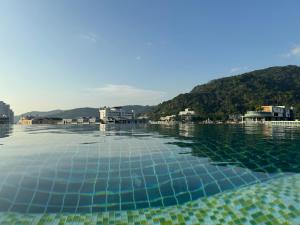 uma piscina de água com uma montanha ao fundo em Zephyr Grand Hotel em Patong Beach