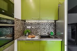 uma cozinha com armários verdes e um lavatório em ShortStayPoland Aleja Rzeczypospolitej (B157) em Varsóvia