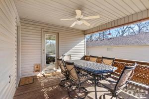 a patio with a table and chairs and a ceiling fan at Cozy Quiet Retreat In The Woods in Bella Vista