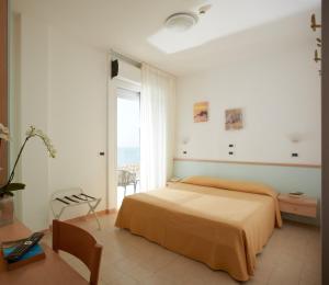 1 dormitorio con cama y ventana grande en Hotel Pelikan en Lignano Sabbiadoro