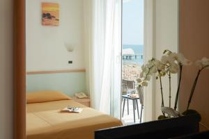 1 dormitorio con cama y vistas al océano en Hotel Pelikan, en Lignano Sabbiadoro