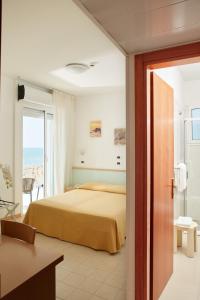 1 dormitorio con 1 cama y balcón en Hotel Pelikan, en Lignano Sabbiadoro
