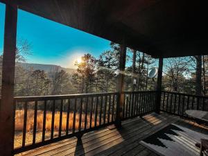 a screened in porch with a view of the mountains at The Hummingbird Haven in Hasty