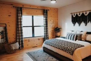 a bedroom with a bed and a large window at The Hummingbird Haven in Hasty
