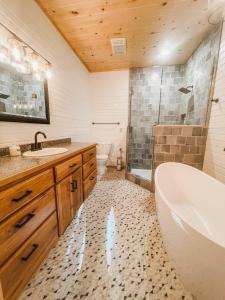 a bathroom with a tub and a toilet and a sink at The Hummingbird Haven in Hasty
