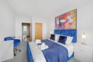 Retreat: Seaside Bliss In Ramsgate في Kent: غرفة نوم بسرير كبير مع بطانية زرقاء