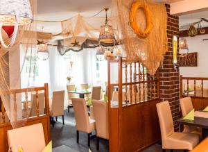 a dining room with tables and chairs and chandeliers at Gasthof zu den Linden 61225 in Moormerland