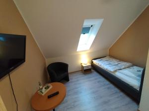 a small bedroom with a bed and a table at Gasthof zu den Linden 61225 in Moormerland