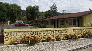 a fence with flowers in front of a house at Lakeview Inn in Lucerne